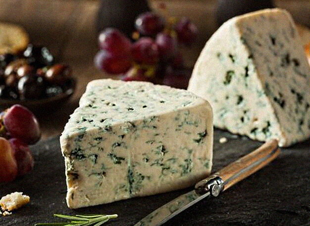 Verschiedene gesunde Käsesorten auf einem Holztisch